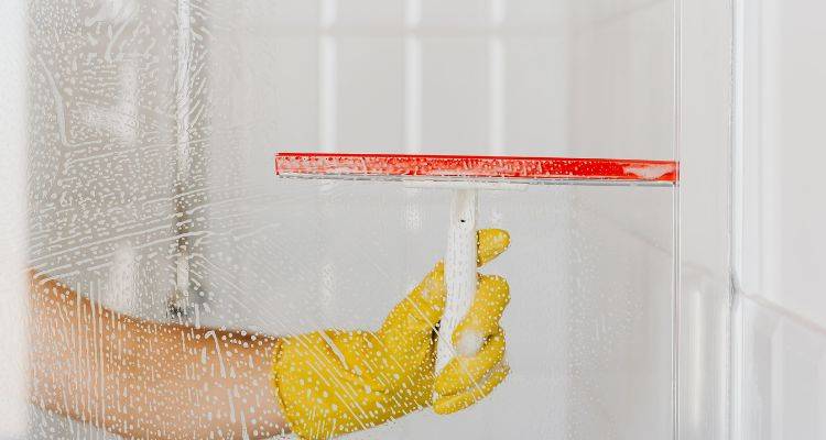 Using a squeegee after shower to prevent water stains
